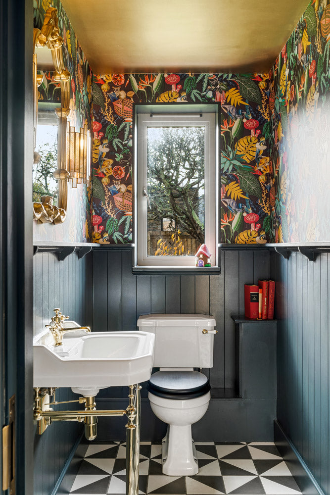 Alice in wonderland inspired wc interior design with gold ceiling and bold wallpaper.